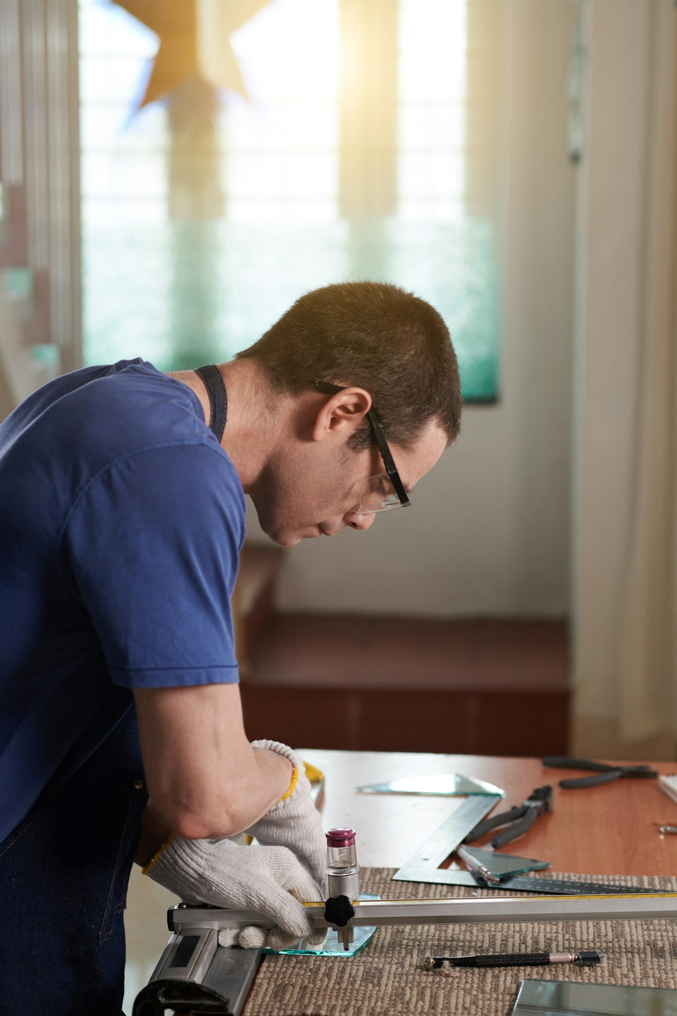 Worker working on lathe with glass